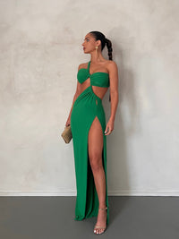 Robe longue verte à bustier torsadé, dos découpé et fente haute sur la jambe.