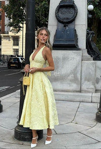 Robe midi jaune à bretelles fines, décolleté plongeant, jupe ample évasée