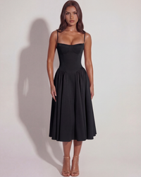 Robe noire à bretelles fines, corsage ajusté et jupe mi-longue plissée