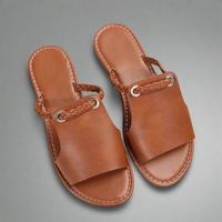 Sandales faites main en cuir brun avec bride tressée et boucles rondes, bout ouvert.