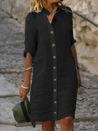 Robe midi noire en lin, col chemise, patte boutonnée, manches retroussées.
