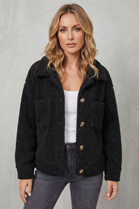 Veste en polaire texturée noire avec col, boutons sur l’avant et poches poitrine boutonnées.