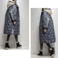 Doudoune longue bleue matelassée, capuche beige, rayures sur les manches, zip