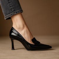 Escarpins élégants noirs en cuir verni, bout pointu, talon fin, bride à nœud.