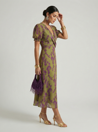 Robe midi imprimée à décolleté cache-cœur, manches bouffantes, fond vert olive et violet.