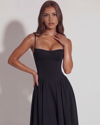 Robe noire à bretelles fines, décolleté en cœur et jupe évasée plissée