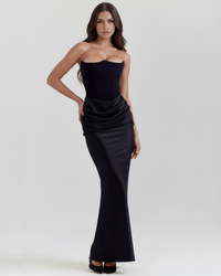 Robe longue noire bustier avec drapé enroulé sur le devant et coupe près du corps.