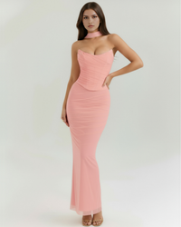 Robe longue moulante rose poudré à encolure cœur et bretelles fines.