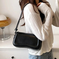 Sac à main à rabat ondulé et bandoulière, cuir vegan noir, fermeture à bouton