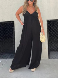 Combinaison à col V noire à fines bretelles, jambes larges et pantalon ample.