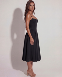 Robe noire de côté, bretelles fines, jupe midi plissée et évasée