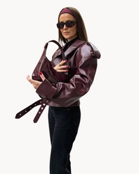 Veste en cuir bordeaux à épaules marquées et col châle, détail de fermeture.