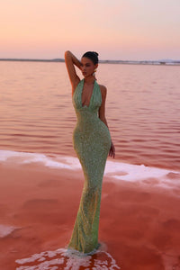 Robe longue à paillettes vert clair, encolure halter et buste ouvert au dos