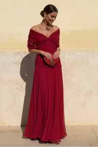 Robe longue à col en V rouge bordeaux, manches bateau, drapée sur la poitrine.