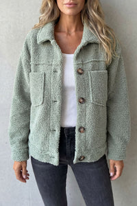 Veste en polaire texturée vert sauge, col en laine, boutons et poches poitrine visibles.