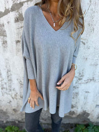 Pull léger col rond bleu clair, manches trois-quarts, coupe ample en maille douce.