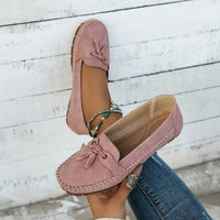 Mocassins orthopédiques en daim rose, bout rond, ruban noué sur l’empeigne, coutures.