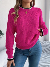 Pull en maille rose fuchsia avec motif relevé, col rond côtelé, bouton doré, poignets rayés