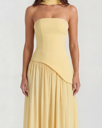 Robe longue jaune sans bretelles avec jupe plissée et empiècement croisé au buste.