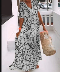 Robe longue noire et blanche à motif floral abstrait, col en V, manches courtes, fluide.