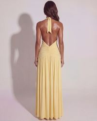 Robe longue jaune vue de dos, nœud arrière, bretelles fines et fronces en cascade.
