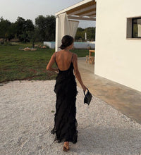 Robe longue noire à volants vue de dos, bretelles fines, cascade de volants et fente.