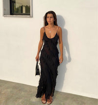 Robe longue noire à volants et décolleté en V, bretelles fines, coupe près du corps.