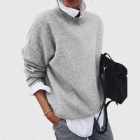 Pull ample col rond gris clair en maille, manches longues et coupe décontractée.