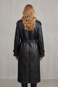 Manteau noir en peau lainée, vue arrière, ceinture à nouer, capuchon d’épaule