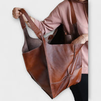 Sac de voyage surdimensionné en cuir marron, anses longues et ouverture sur le dessus