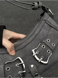 Mini-sac à bandoulière gris, gros plan sur la poche et les œillets avec boucles métalliques