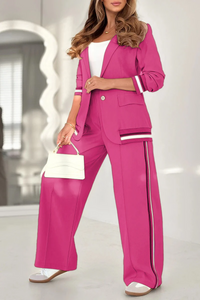 Ensemble femme fuchsia : veste courte et pantalon large avec bandes verticales et poches plaquées.