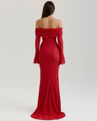 Robe rouge longue près du corps, dos nu bardot, manches évasées, dentelle texturée.