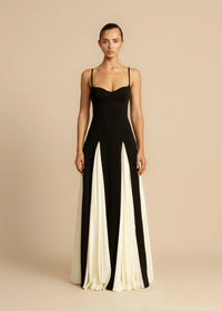 Robe longue noire à bretelles fines et volants contrastés blanc cassé.