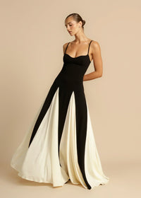 Robe longue noire à volants blanc cassé, bretelles fines et décolleté plongeant.