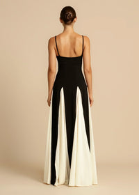 Robe longue noire à bretelles fines, dos nu, volants contrastés blanc cassé.