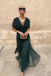 Robe longue vert profond à col en V, silhouette ajustée, jupe ample avec volants.