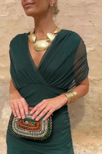 Robe longue à col en V vert profond, détail drapé au buste, tissu léger et fluide.