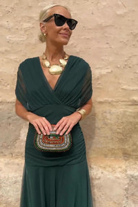 Robe longue à col en V vert profond, drapé au buste, jupe fluide en voile.