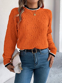 Pull en tricot orange texturé, encolure ronde avec bord rayé blanc/noir et manches longues