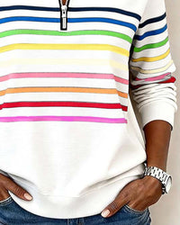 Haut sweat demi-zip blanc à rayures multicolores, poche latérale et zip central.