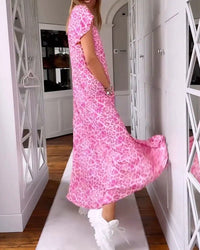 Robe longue rose à imprimé léopard, encolure en V, coupe ample, ourlet asymétrique.