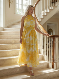 Robe midi dos nu froncée jaune à motifs tie-dye, bretelles fines et taille froncée.