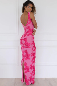 Robe longue rose fuchsia à fleurs, dos échancré, sans manches, coupe moulante.