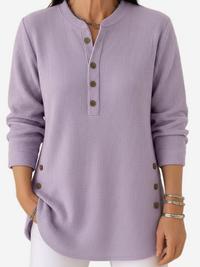 Pull boutonné en maille côtelée lilas, encolure ronde, manches longues.