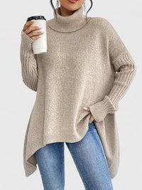 Col roulé en maille chaude beige clair, coupe ample et ourlet asymétrique, manches longues côtelées.