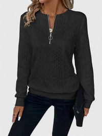 Pull noir à zip discret, manches longues, texture torsadée, bas et poignets côtelés