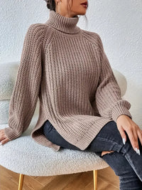 Pull col roulé en maille côtelée beige, coupe ample, détail de couture sur le côté.