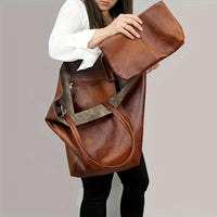 Grand sac cabas rétro marron porté avec pochette intérieure et anses longues.