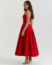 Robe rouge bustier sans bretelles, jupe évasée et talons.